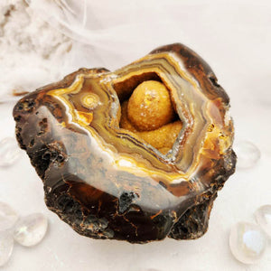 Agate geode with banded golden rings surrounding a hollow druzy centre
