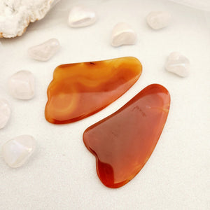 Polished agate gua sha tool in soft curved shape.