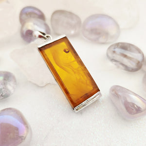 Rectangular warm honey amber pendant with sterling silver end cap setting and bail