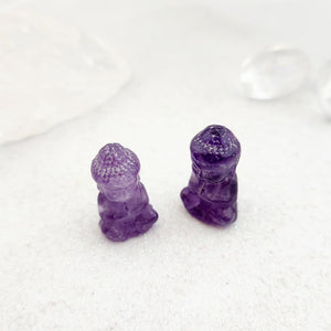 Small amethyst Buddha carving with soft purple colouring.