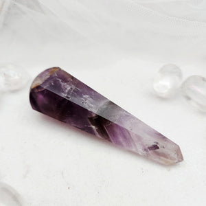 Polished amethyst wand with a faceted point and deep purple tone