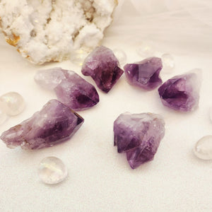 Natural Amethyst point with soft purple tones and raw edges.