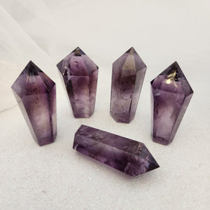 Polished amethyst point with smooth facets and deep purple colouring