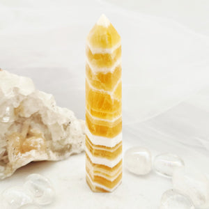 Tall orange calcite point with faceted tip and bold horizontal banding.