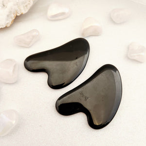 Black Obsidian Gua Sha tool with smooth curved shaping and polished finish.