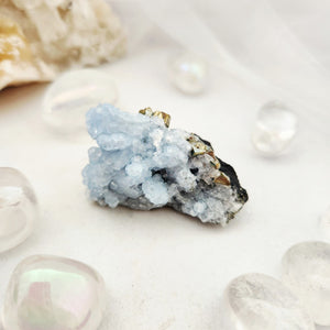 Pale blue fluorite cluster with druzy texture and metallic pyrite flecks.