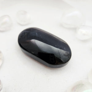 Smooth blue tiger's eye palm stone with a deep, glossy dark surface