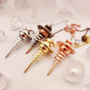 Four pendulums grouped together in silver, copper, gold and rose tones.
