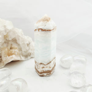 Tall Caribbean calcite point with faceted tip and pale blue-white banding.