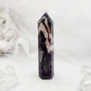 Polished chevron amethyst point with tall faceted form and bold banding