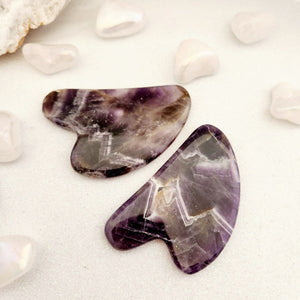 Polished chevron amethyst gua sha tool in soft curved shape.