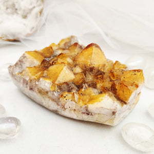 Citrine cluster with faceted golden points on a flat, cut base