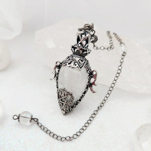 Ornate silver-caged pendulum with clear quartz teardrop stone.