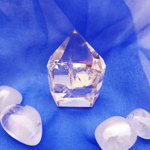 Compact clear quartz point with faceted tip and stout base.