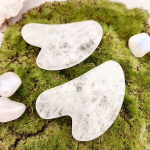 Clear quartz gua sha tool with smooth polished shape.