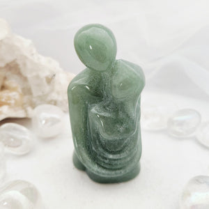 Green aventurine carving of an embracing couple with rounded forms.