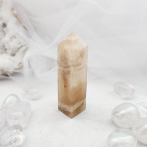 Polished moonstone obelisk with a tapered point and warm cream tone