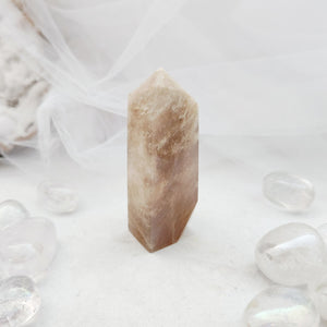 Polished moonstone obelisk with a tapered point and soft peachy tone