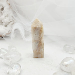 Polished grey moonstone obelisk with a tapered point and pale cream tone
