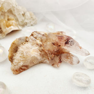 Fan-shaped quartz cluster with jagged points and rusty red tones