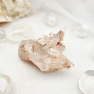 Jagged quartz cluster with multiple pointed terminations and rusty tones.