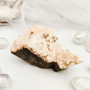 Heulandite and apophyllite cluster with pale pink crystals on dark matrix