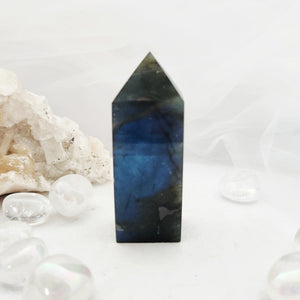 Labradorite obelisk with a faceted tip and dark grey body.
