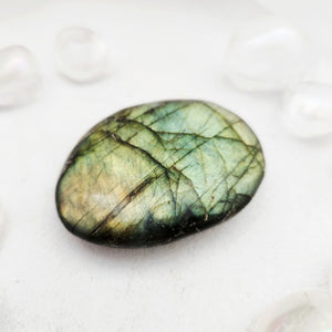 Smooth labradorite palm stone with golden-green flash and dark edges