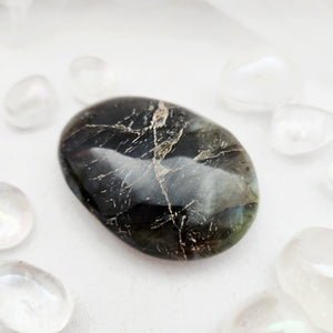 Smooth labradorite palm stone with dark tone and fine golden veining
