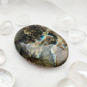 Smooth labradorite palm stone with mottled tones and streaks of blue flash