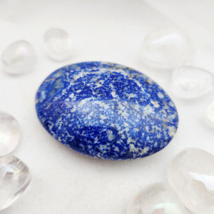 Smooth lapis lazuli palm stone with deep blue and white flecked pattern