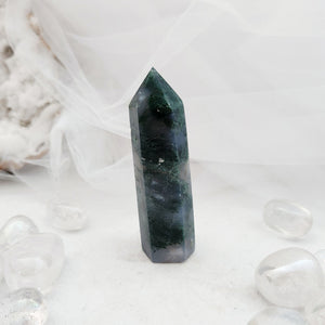 Polished moss agate point with a faceted top and deep green tone
