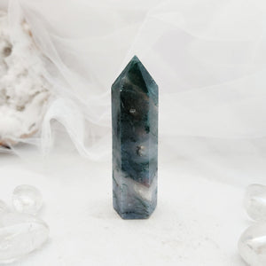 Polished moss agate point with a faceted top and green mossy inclusions