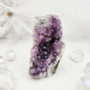 Natural amethyst cluster with purple points and a flat, cut base