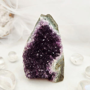 Natural amethyst cluster with purple points and a flat, cut base