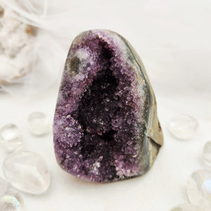 Natural amethyst cluster with purple points and a flat, cut base