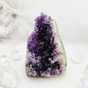 Natural amethyst cluster with purple points and a flat, cut base