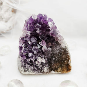 Natural amethyst cluster with purple points and a flat, cut base