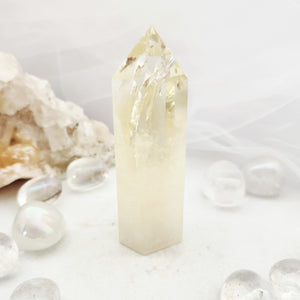 Tall citrine point with a jagged textured tip and pale golden base.