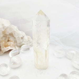 Tall citrine point with a faceted tip and pale golden hue.