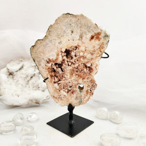 Pink amethyst cluster on a black display stand with druzy texture
