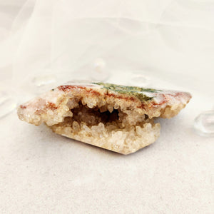 Narrow Pink Amethyst geode with polished sections and textured outer surface.