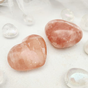 Polished pink calcite heart with soft peach tone and fine striations