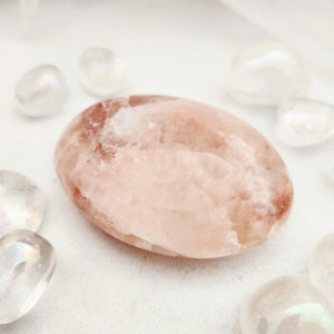 Smooth pink calcite palm stone with soft rusty-pink veining