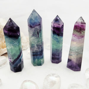 Faceted rainbow fluorite point with sharp pointed tip and banded colour.