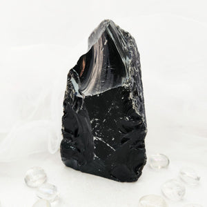 Raw black obsidian chunk with jagged edges and a flat cut base.