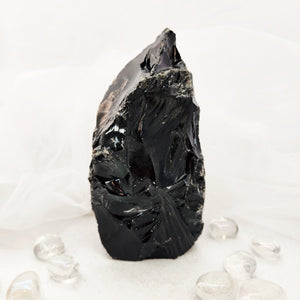 Raw black obsidian chunk with jagged edges and a flat cut base.