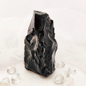 Raw black obsidian chunk with jagged edges and a flat cut base.