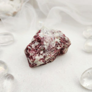 Raw specimen with deep pink tourmaline speckled through white quartz