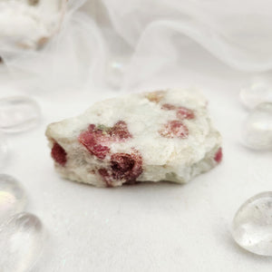 Raw specimen with pink tourmaline crystals embedded in white quartz